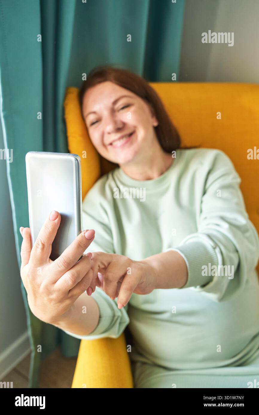 Jeune femme se faisant autoportrait à l'intérieur.Portrait de vacances à la maison.Selfie blogueur Banque D'Images