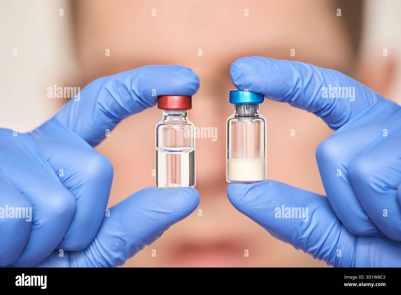 Personne masculine dans des gants bleus tient des bouteilles de vaccin. Pharmacie de drogues injectables Banque D'Images