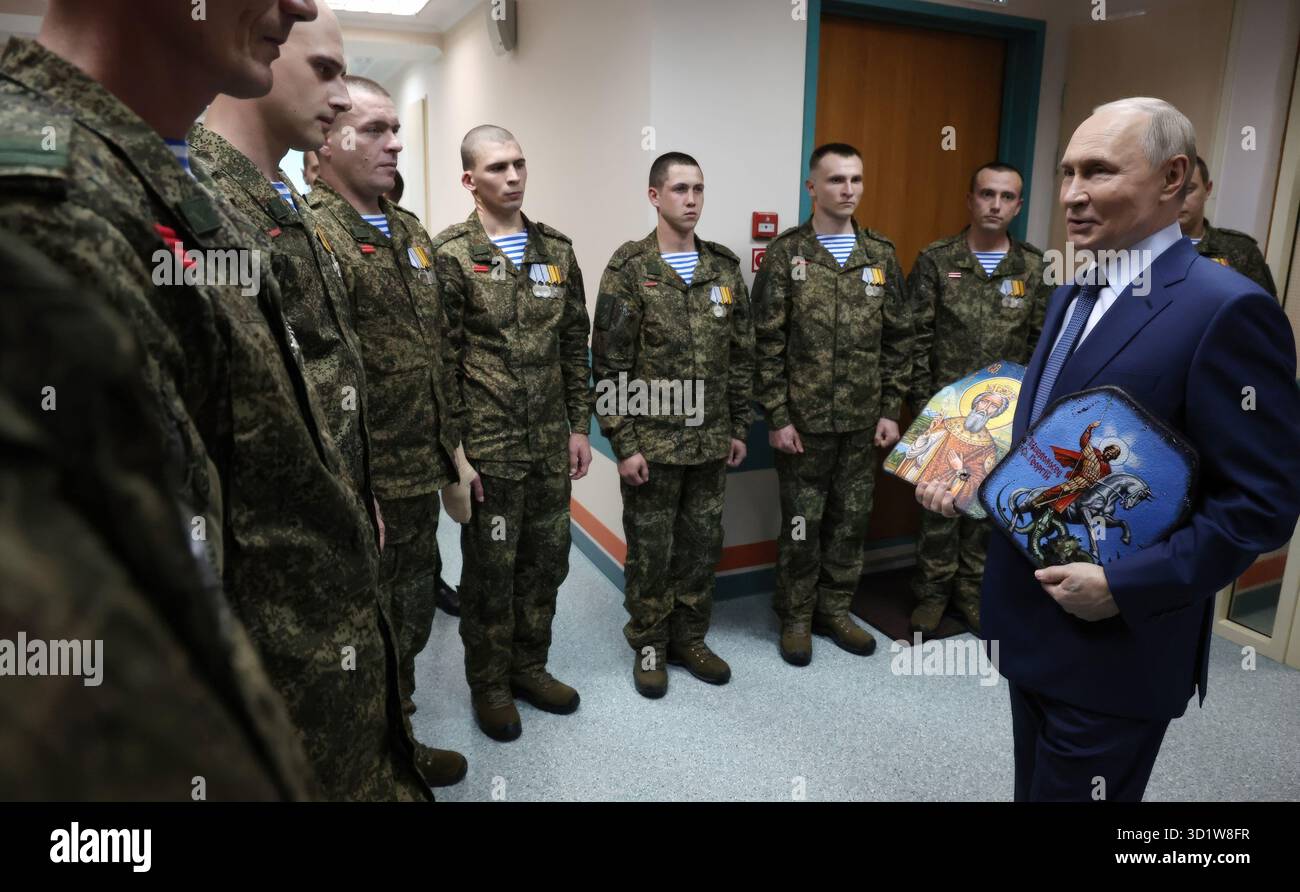 Moscou, Russie. 29 octobre 2025. Le président russe Vladimir Poutine s’entretient avec des militaires de la 127e Brigade de reconnaissance séparée lors d’une visite à l’hôpital clinique militaire central Mandryk, le 29 octobre 2025 à Moscou, en Russie. Les soldats ont donné à Poutine des icônes religieuses avec des éclats d'obus et des marques de balles pour son anniversaire. Crédit : Vyacheslav Prokofyev/Kremlin Pool/Alamy Live News Banque D'Images