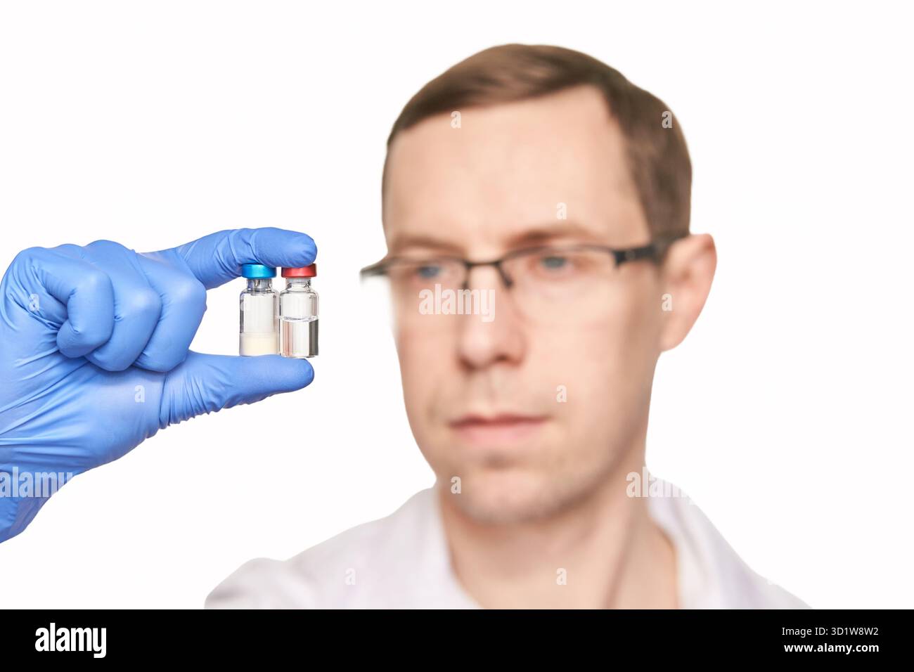 Personne masculine dans des gants bleus tient des bouteilles de vaccin. Pharmacie de drogues injectables Banque D'Images