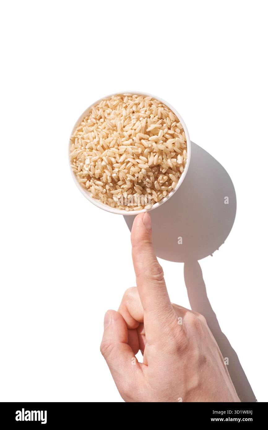 Un bol de riz brun non cuit, isolé sur fond blanc. En bonne santé Banque D'Images