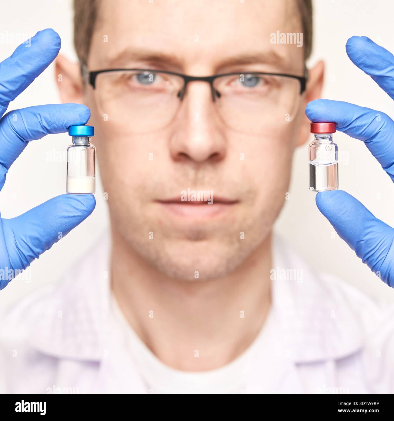 Un homme dans un gant bleu tient des bouteilles de vaccin. Concept de pharmacie par injection Banque D'Images
