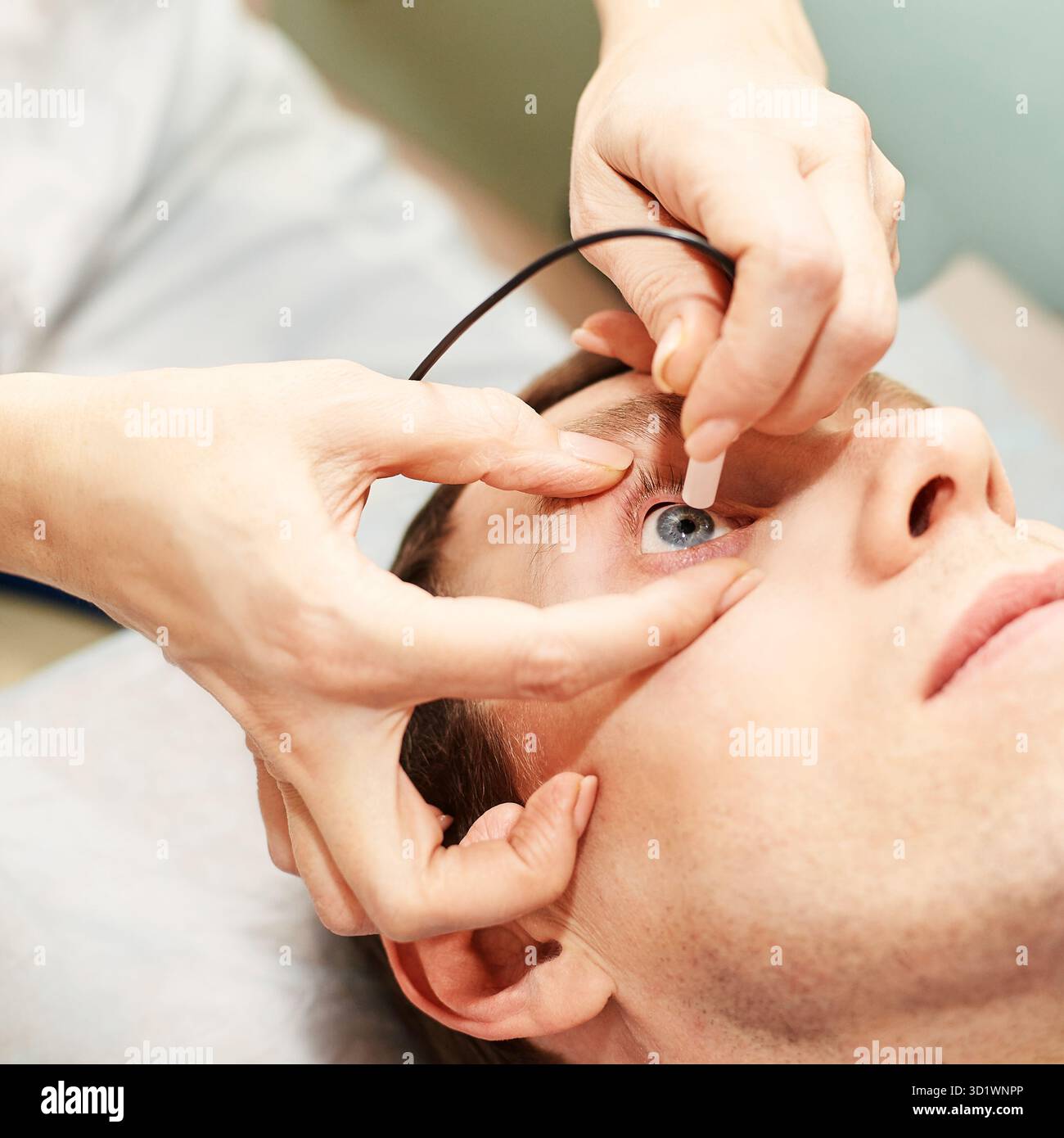 Médecin ophtalmologiste en laboratoire opticien d'examen avec patient masculin. Yeux hommes Banque D'Images