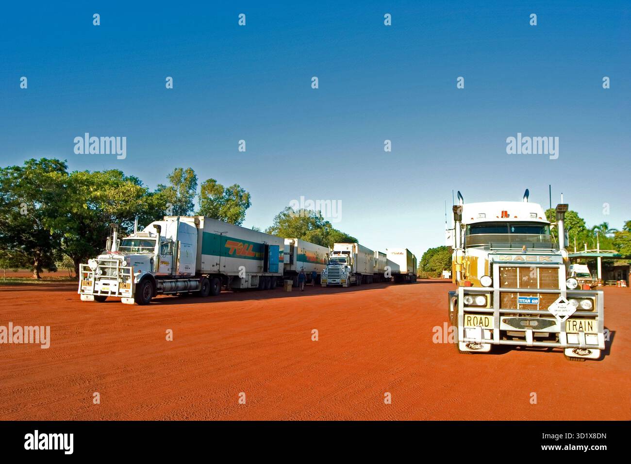 Des trains routiers australiens stationnés sur de la terre rouge à un arrêt de camion isolé dans l'Outback, territoire du Nord, Australie Banque D'Images
