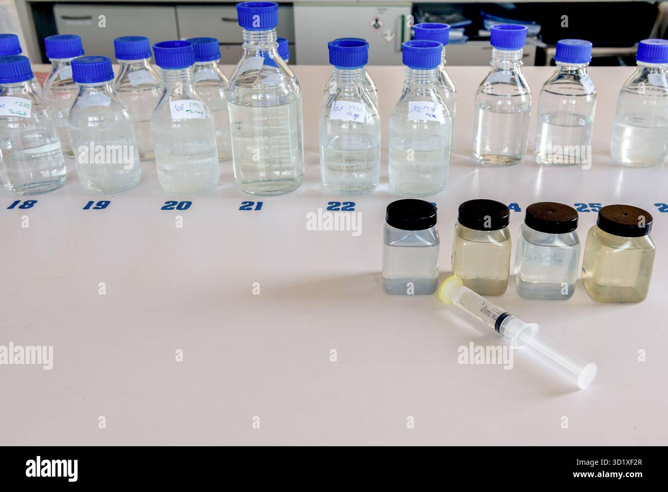 Équipement de laboratoire. Flacons de stockage de laboratoire avec bouchon bleu en polypropylène et flacons en plastique sur table blanche. Banque D'Images