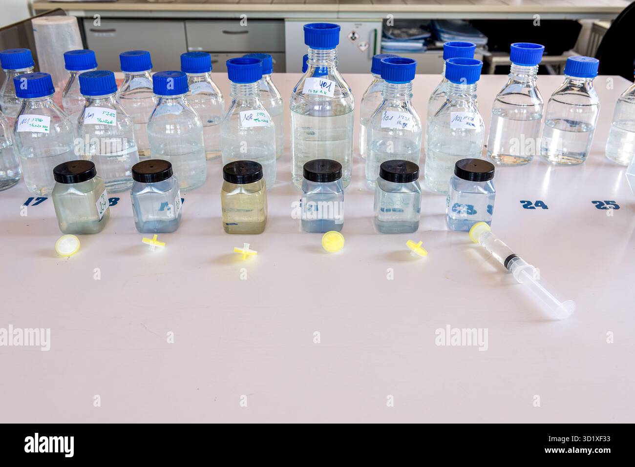 Équipement de laboratoire. Flacons de stockage de laboratoire avec bouchon bleu en polypropylène et flacons en plastique sur table blanche. Banque D'Images