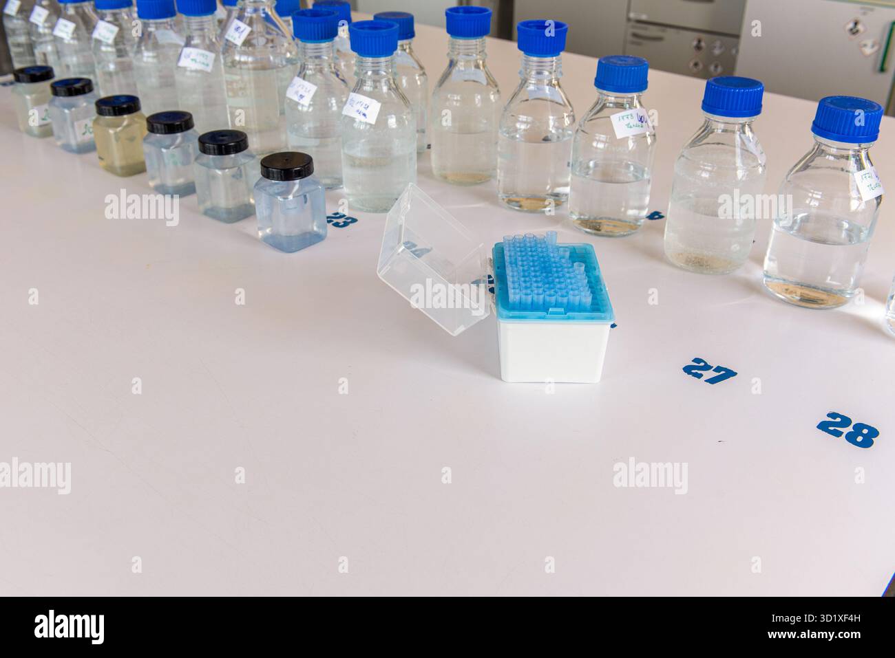 Équipement de laboratoire. Flacons de stockage de laboratoire avec bouchon bleu en polypropylène et flacons en plastique sur table blanche. Banque D'Images