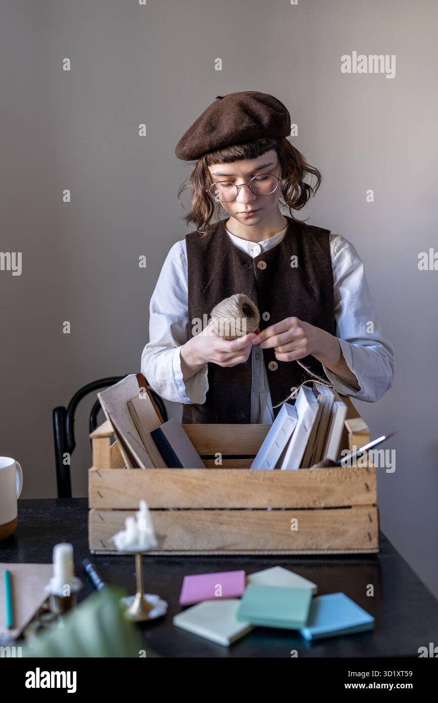 Artiste en milieu de travail. Fille hipster créative debout table et dispose des outils d'art et des matériaux de dessin Banque D'Images