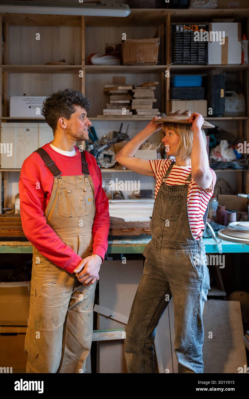 Les charpentiers de couple communiquent sur le lieu de travail. Les conjoints prennent une pause en bavardant des idiots entre les heures de travail Banque D'Images