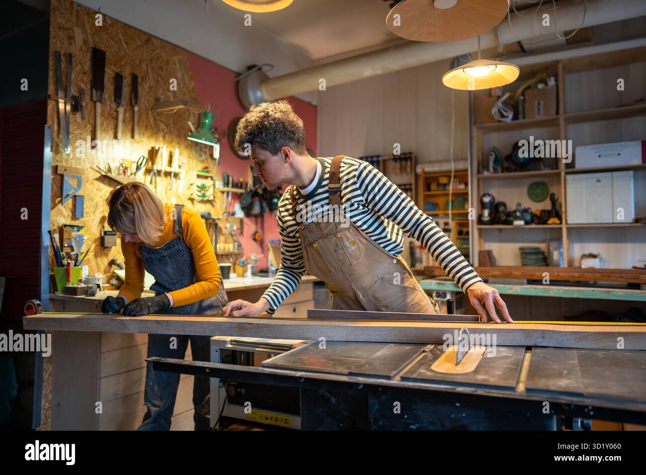 Les artisans travaillent dans un atelier de menuiserie. Professionnels travaillant avec du bois, prenant des mesures Banque D'Images