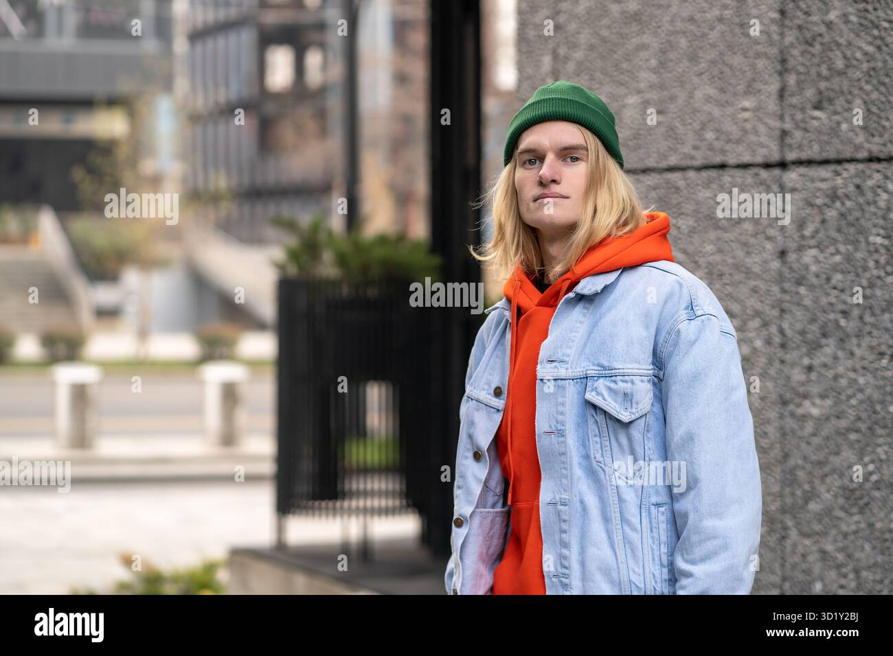 Portrait de rue de gars élégant confiant insouciant dans la tenue colorée à la mode regardant la caméra Banque D'Images