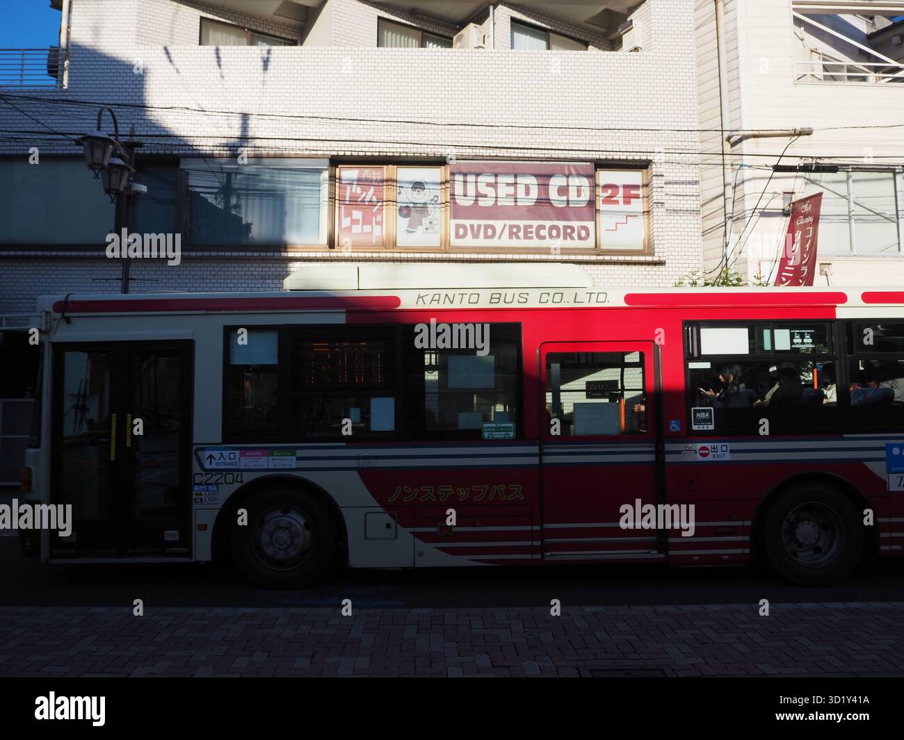 Bus Kanto passant devant un CD usagé et un magasin de disques lors d'un après-midi d'automne ensoleillé à Ogikubo Banque D'Images