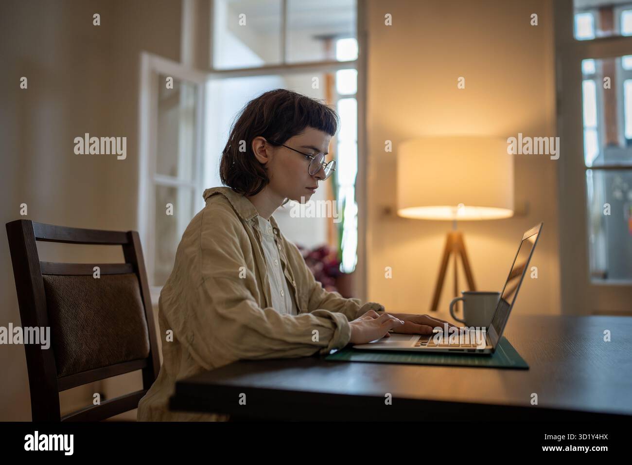 Focalisé fille freelance travaillant sur ordinateur portable se trouve dans le lieu de travail à la maison, apprendre la langue anglaise en ligne Banque D'Images
