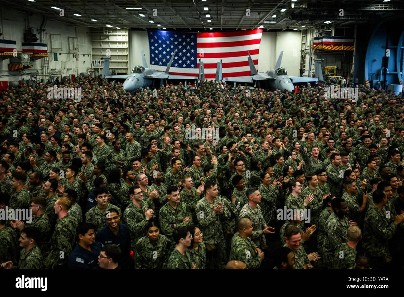 Les militaires américains à bord de l’USS George Washington se réunissent pour entendre les remarques du président Donald Trump à la base navale de Yokosuka, au Japon, le 28 octobre 2025. Le discours a célébré l’unité, le partenariat et la préparation militaire sous la bannière « la paix par la force ». Image reproduite avec l'aimable autorisation de la Maison Blanche. Banque D'Images