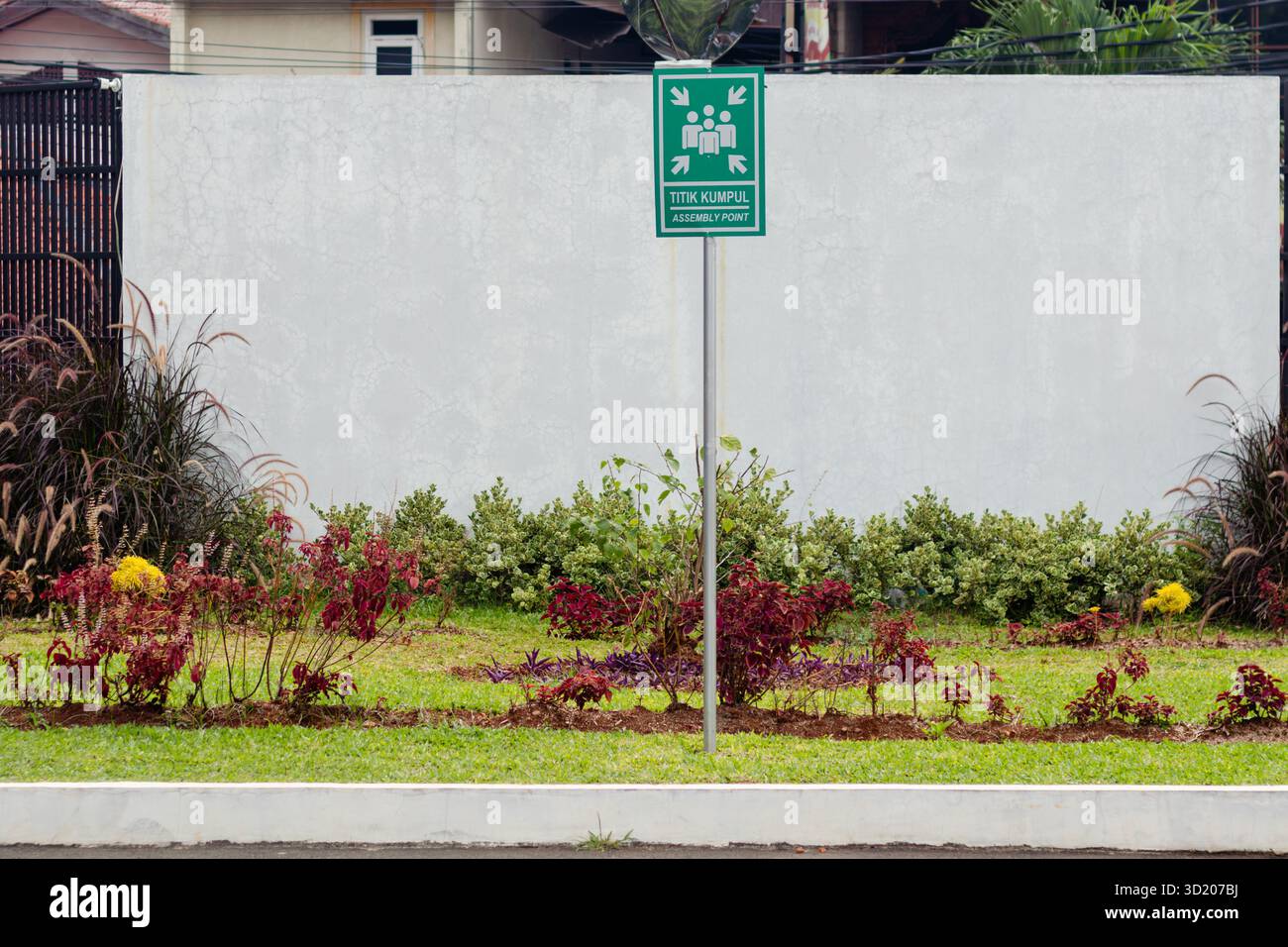 Panneau de point de rassemblement d'urgence en indonésien et en anglais. Signe de point de rassemblement en deux langues. Banque D'Images
