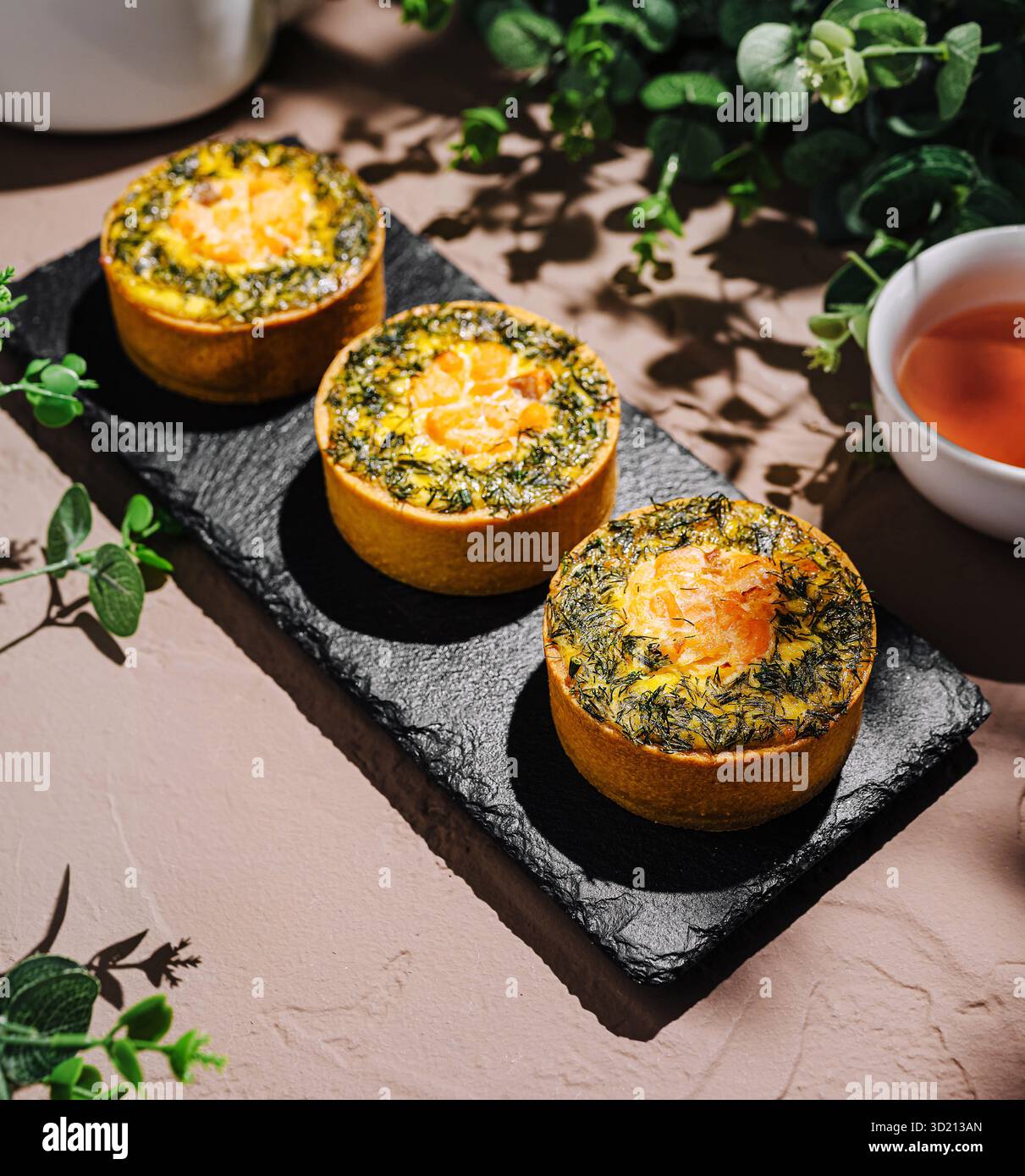 Tartes aux herbes salées servies sur une assiette en ardoise sombre Banque D'Images
