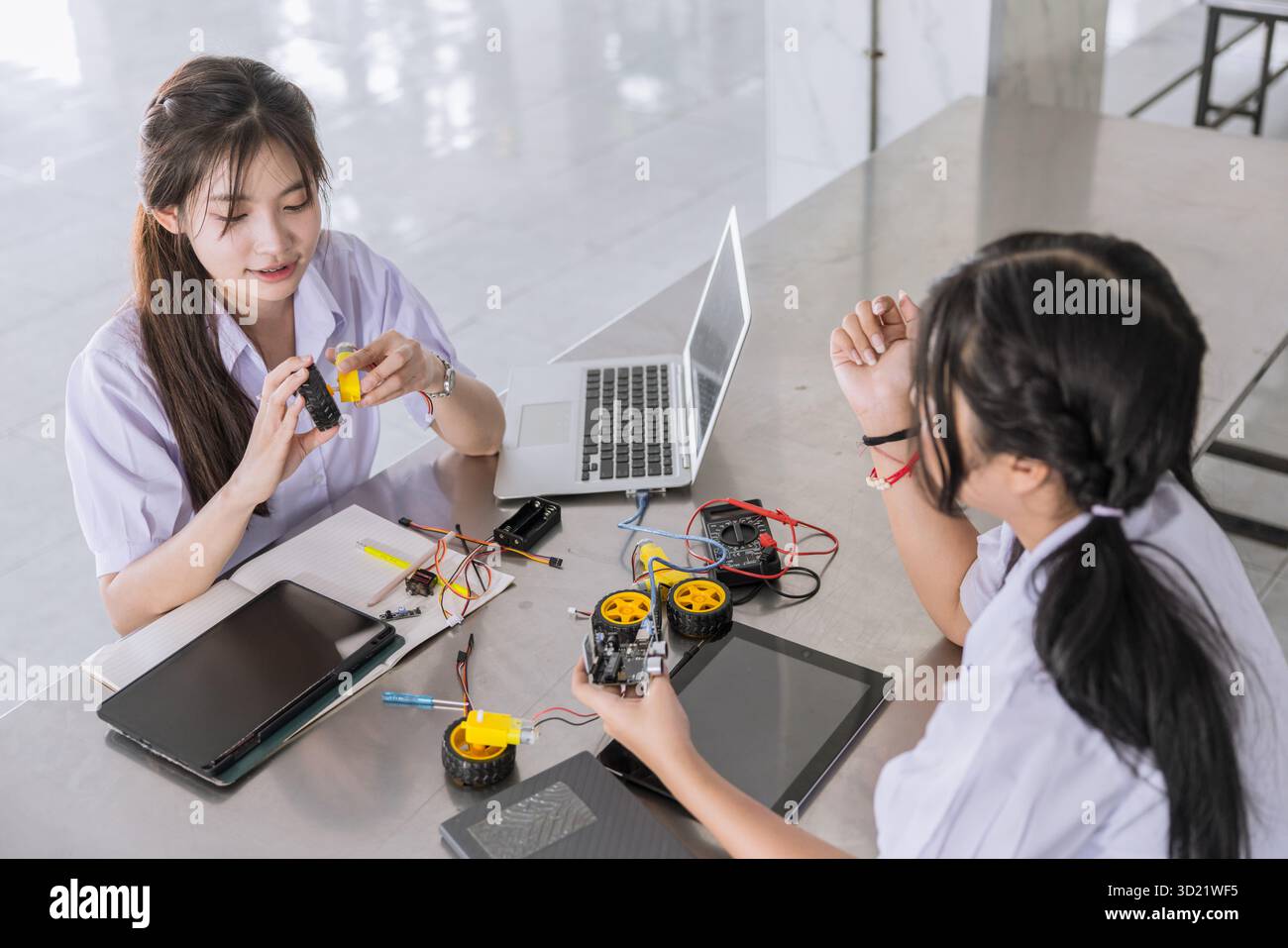 Étudiants adolescents dans l'apprentissage uniforme STEM avec composant de carte de circuit électrique iot sur le campus de l'école Banque D'Images