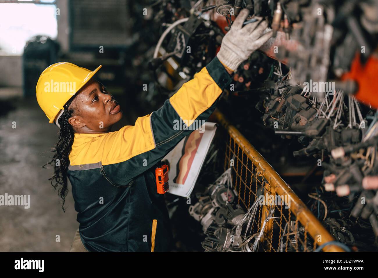 Travailleuse africaine du personnel d'ingénieur noire travaillant dans l'ancien entrepôt de stock de pièces de machines métalliques usagées. Banque D'Images