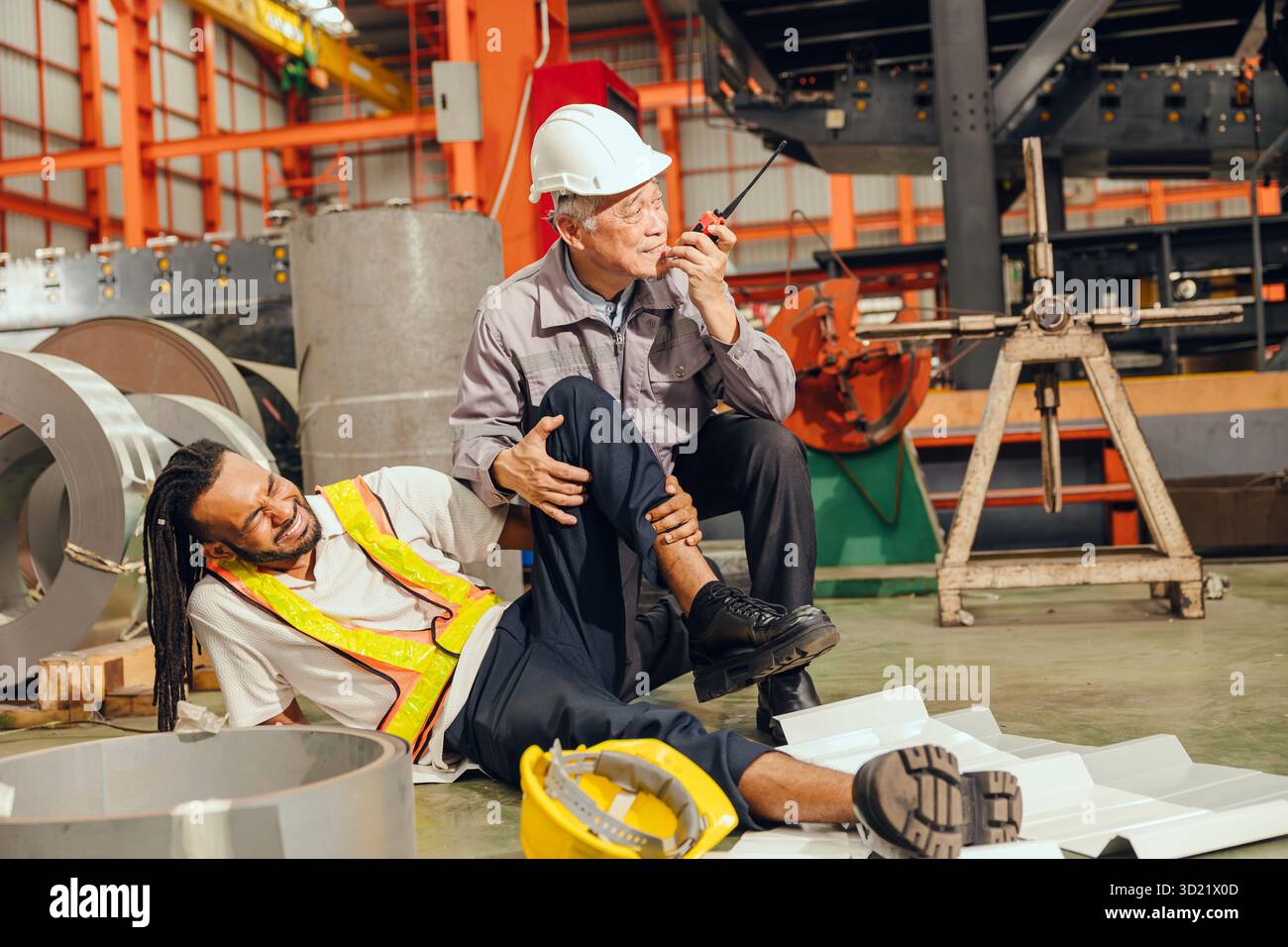 Travailleur accidenté sur le lieu de travail, jeune homme en bas blessure à la jambe superviseur principal directeur de l'usine appel d'urgence pour une aide médicale Banque D'Images