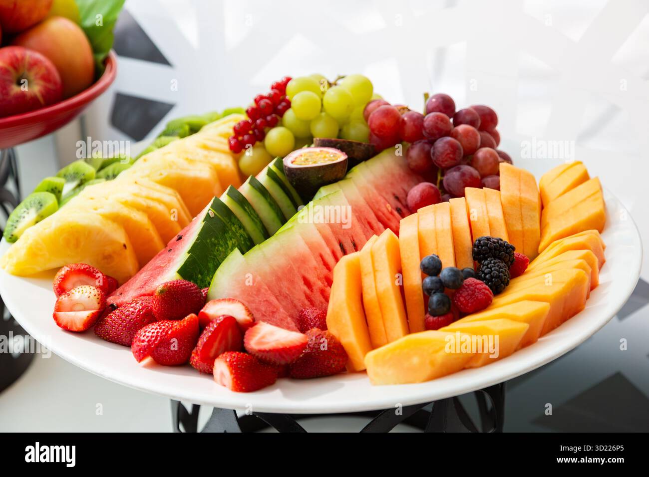 Assortiment de fruits fraîchement coupés sur un plateau, avec pastèque et baies vibrantes Banque D'Images