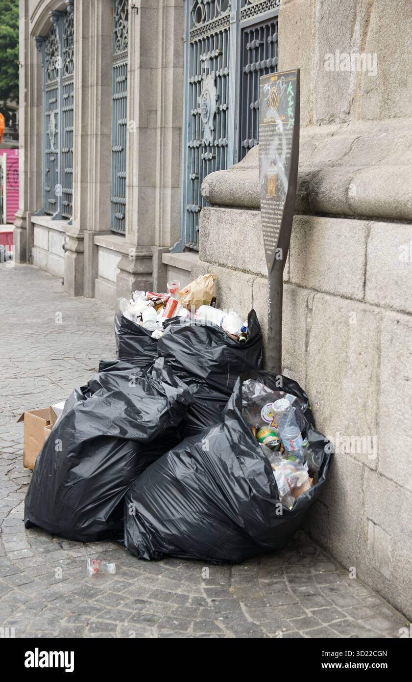 Débordement de sacs poubelles polluant la rue de la ville Banque D'Images