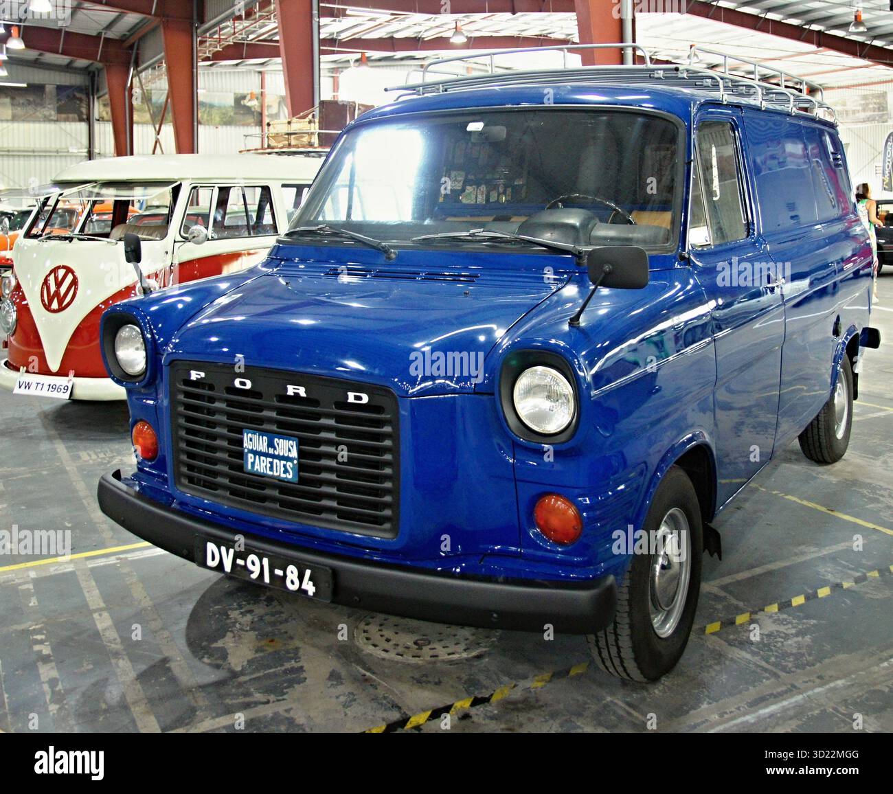 Fourgonnette Ford transit bleue classique avec galerie de toit garée dans un garage à côté d'une Volkswagen Kombi Banque D'Images