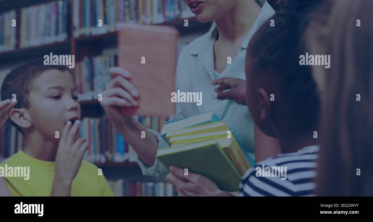 Tenant des livres à couverture rigide colorés bibliothécaire affichant des pages de livre ouvertes aux enfants dans la bibliothèque de l'école Banque D'Images