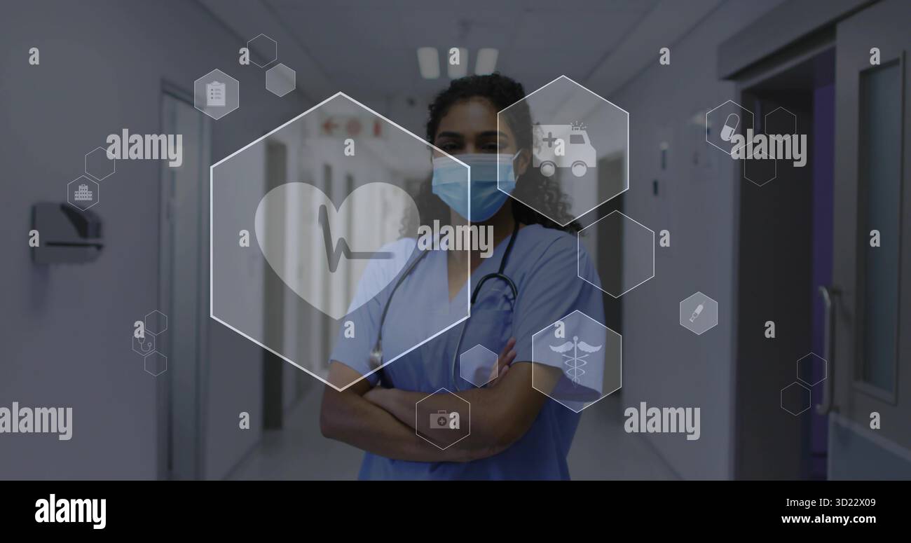 Infirmière pliant les bras dans les gommages, masque chirurgical dans le couloir de l'hôpital avec stéthoscope et icônes médicales Banque D'Images