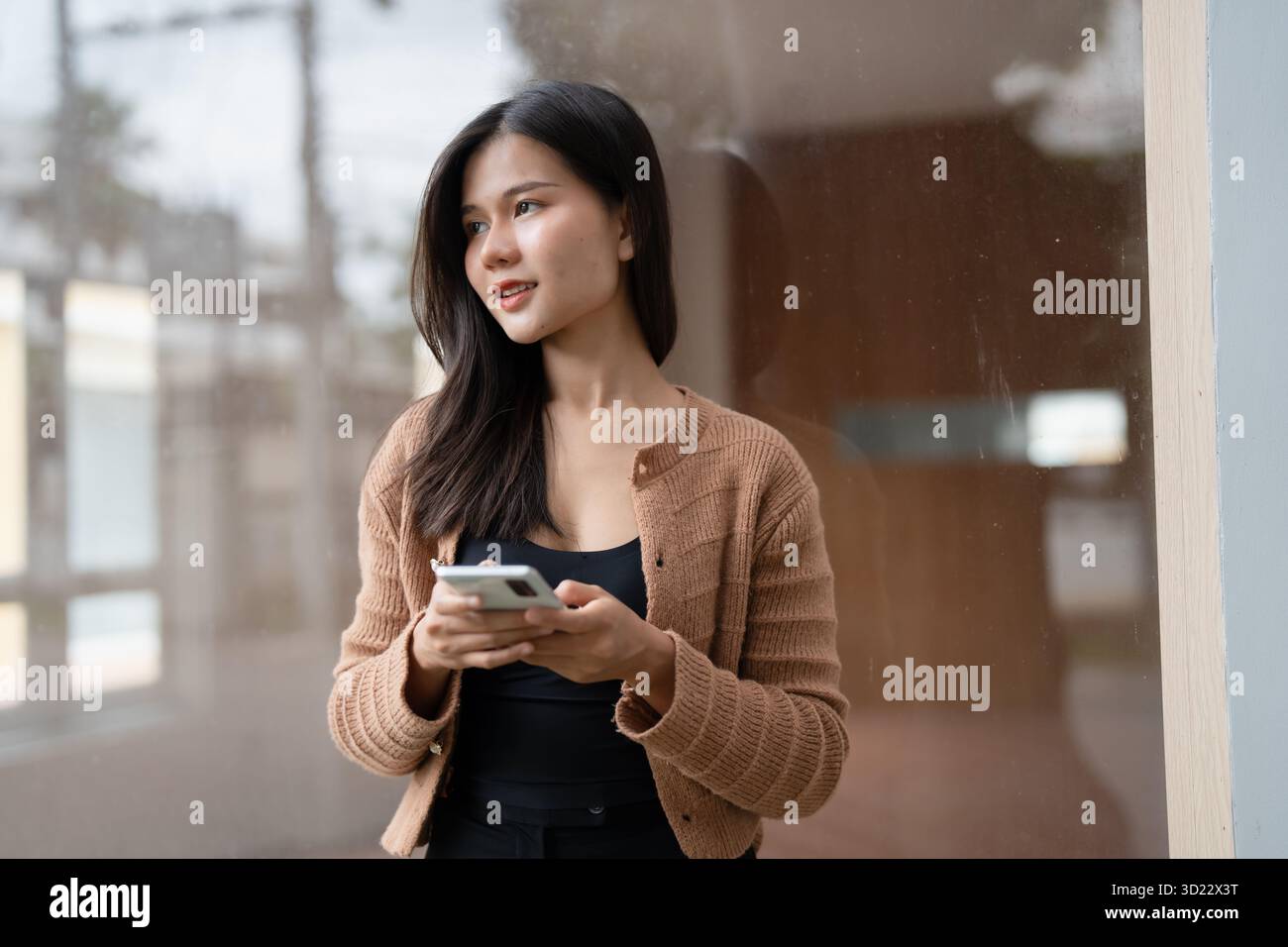 Jeune femme asiatique utilisant smartphone pour la communication d'entreprise en plein air dans la ville urbaine. Banque D'Images