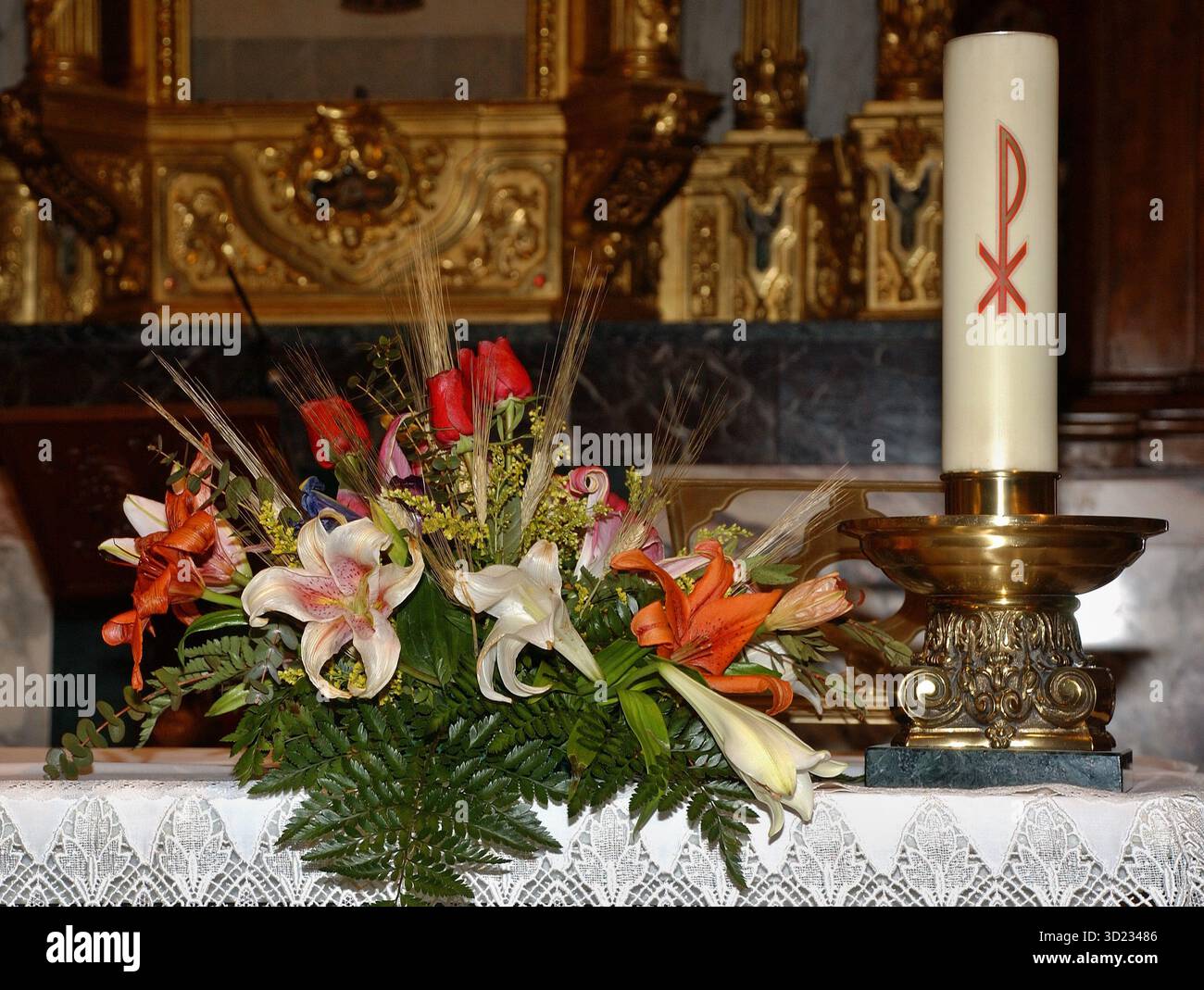 Bougie Pascal et fleurs décorant un autel d'église Banque D'Images