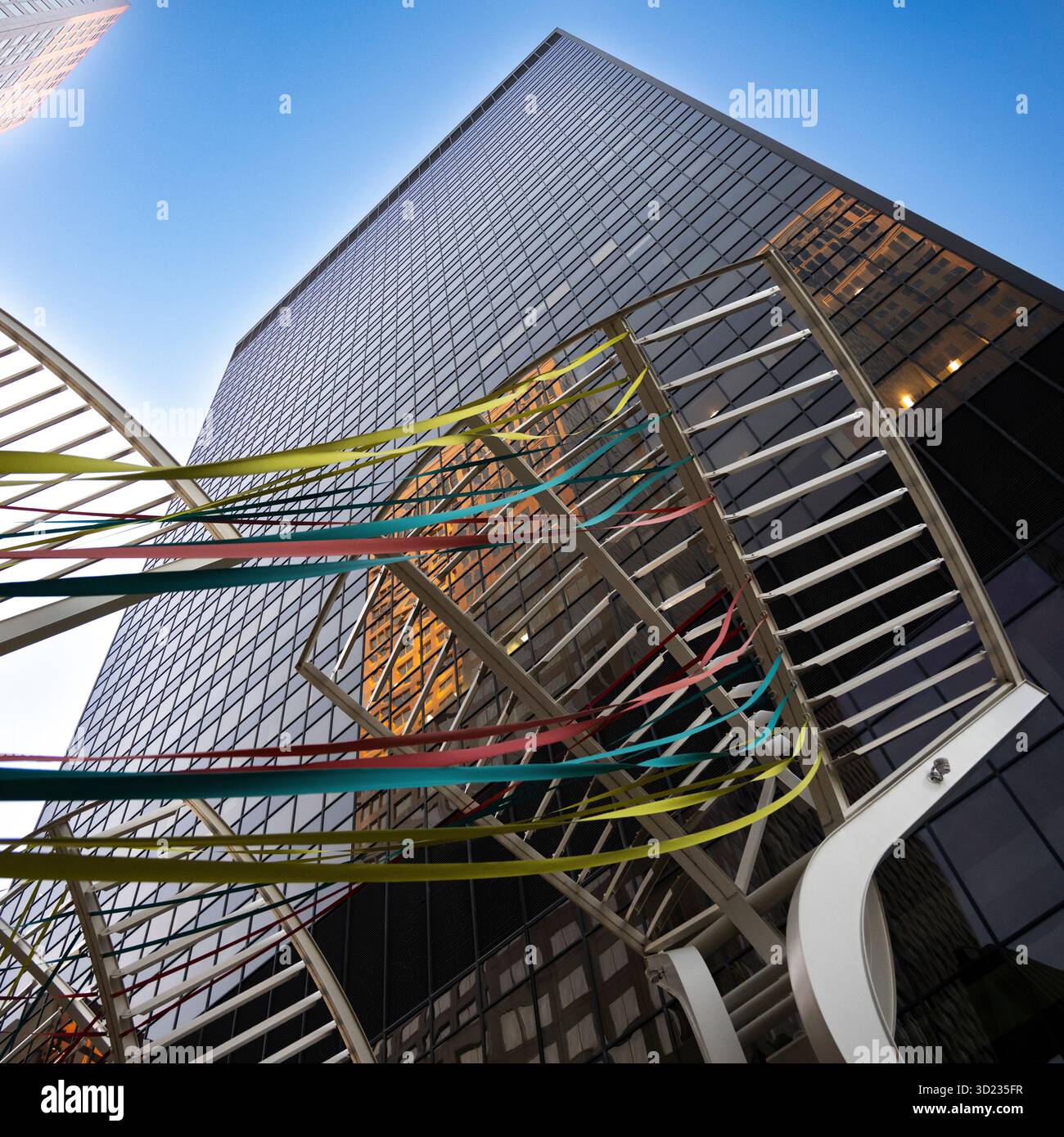 Gratte-ciel avec des poutres colorées contre un ciel bleu clair vu d'en bas dans un cadre urbain. Calgary, Alberta, Canada Banque D'Images