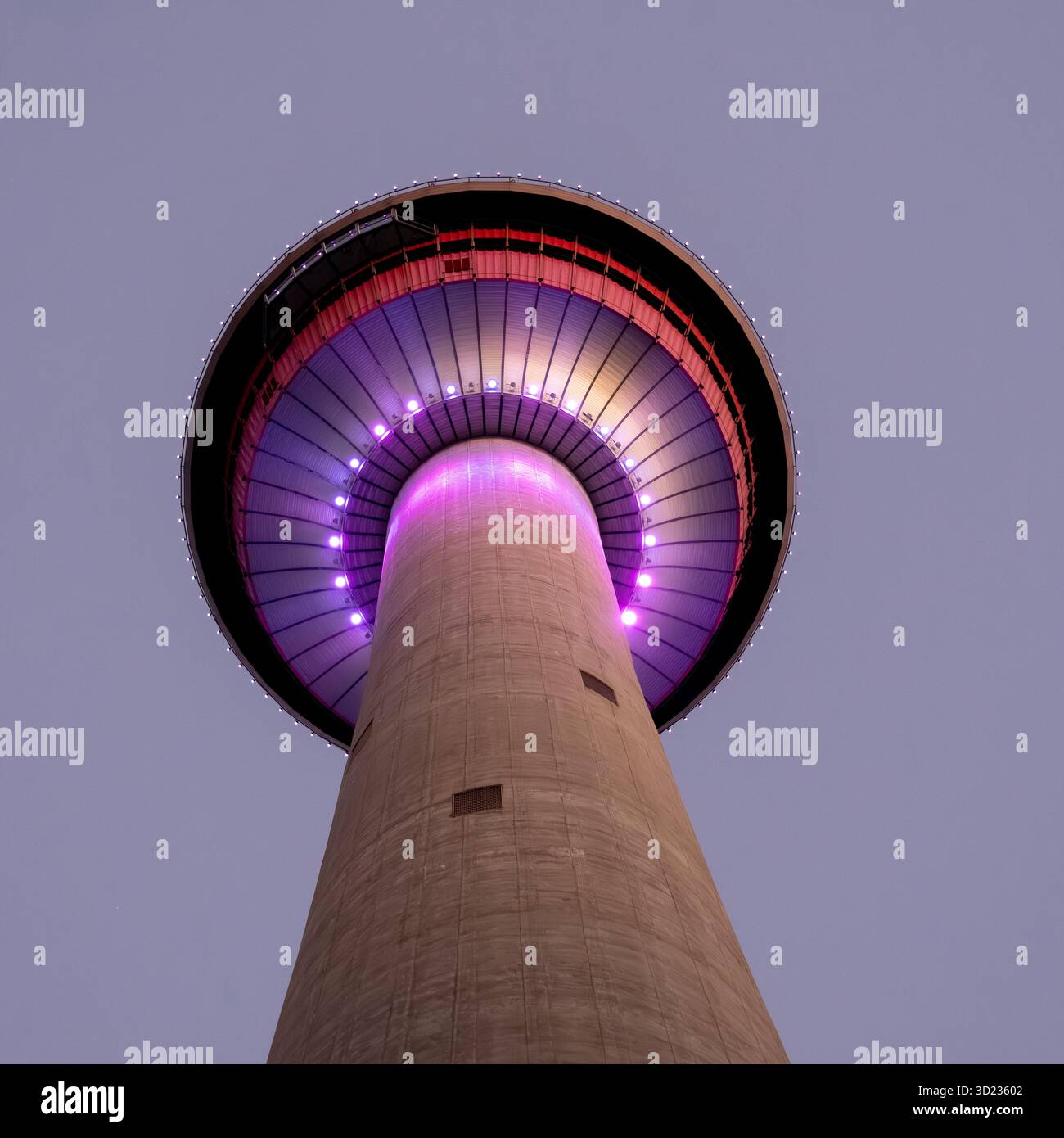 Tour avec des lumières violettes incandescentes contre un ciel crépusculaire, vue d'en bas. Calgary, Alberta, Canada Banque D'Images