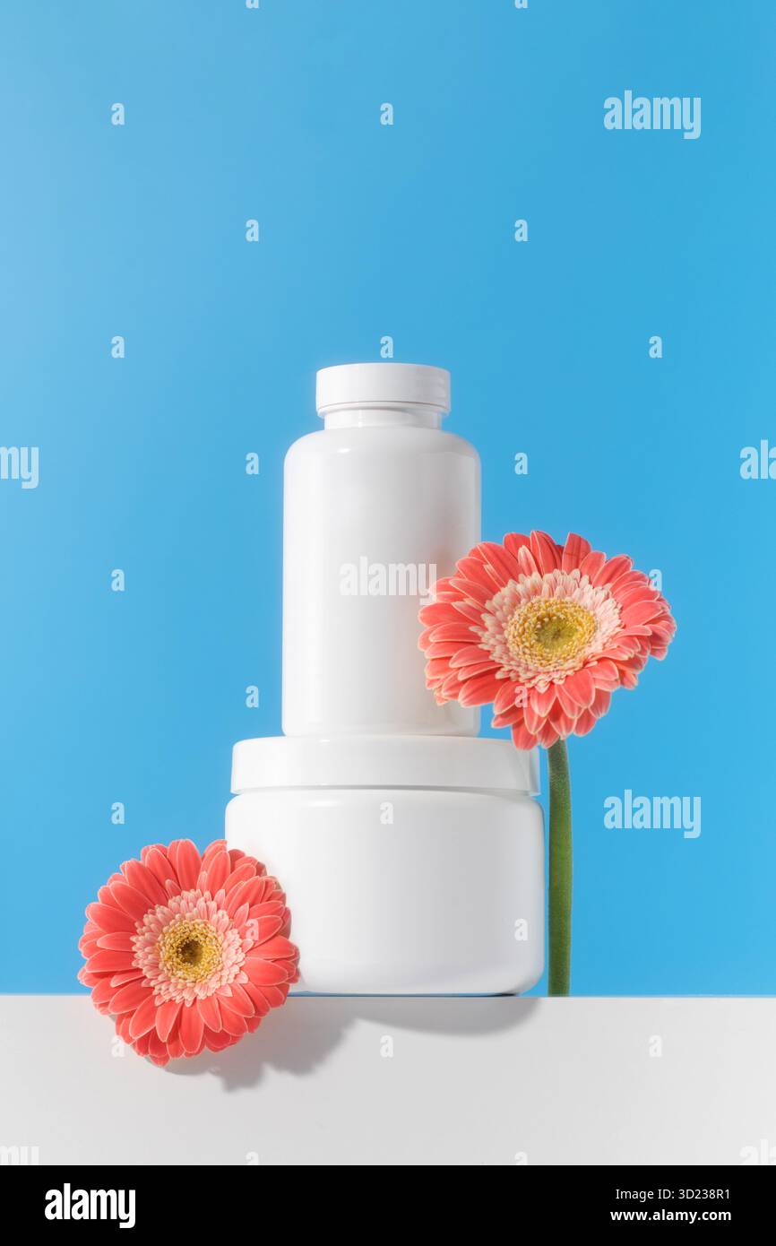 Mockup est un pot blanc avec des pilules ou des vitamines sur un podium. Vitamines pour femmes Banque D'Images