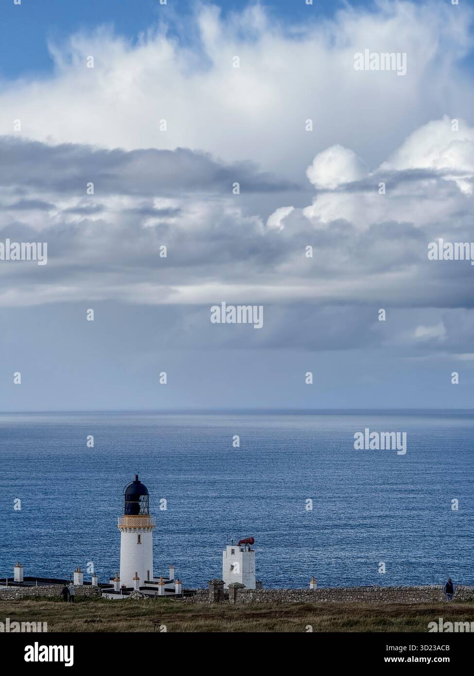 Phare surplombant un vaste océan bleu sous un ciel dramatique avec des nuages blancs. Dunnet Head, Écosse Banque D'Images