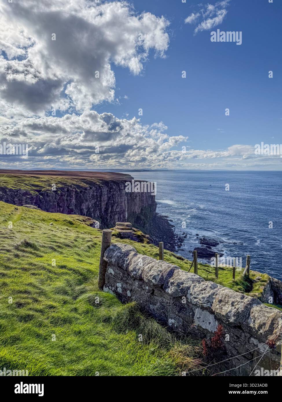 Les falaises côtières escarpées rencontrent le vaste océan sous un ciel bleu nuageux spectaculaire. Dunnet Head, Écosse Banque D'Images