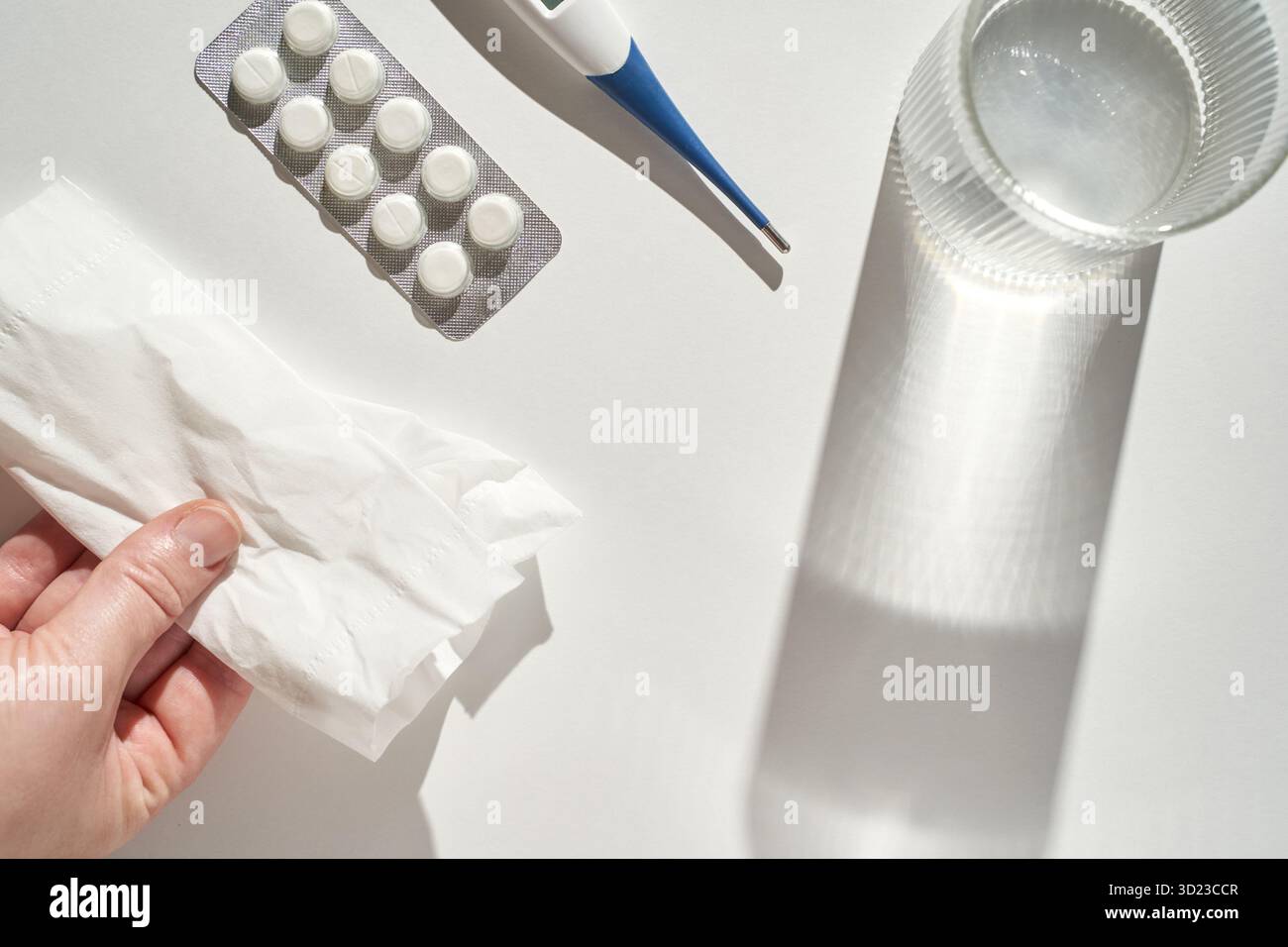 Personne tenant le tissu avec thermomètre de médicaments et verre d'eau pour le froid Banque D'Images