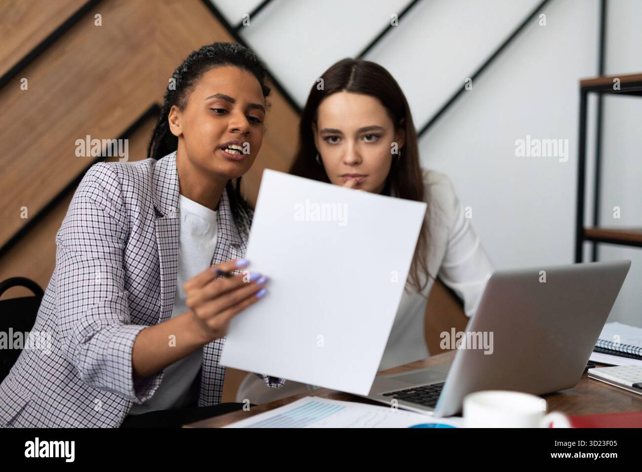 Deux femmes d'affaires sur le lieu de travail dans le bureau travaillent avec des documents Banque D'Images