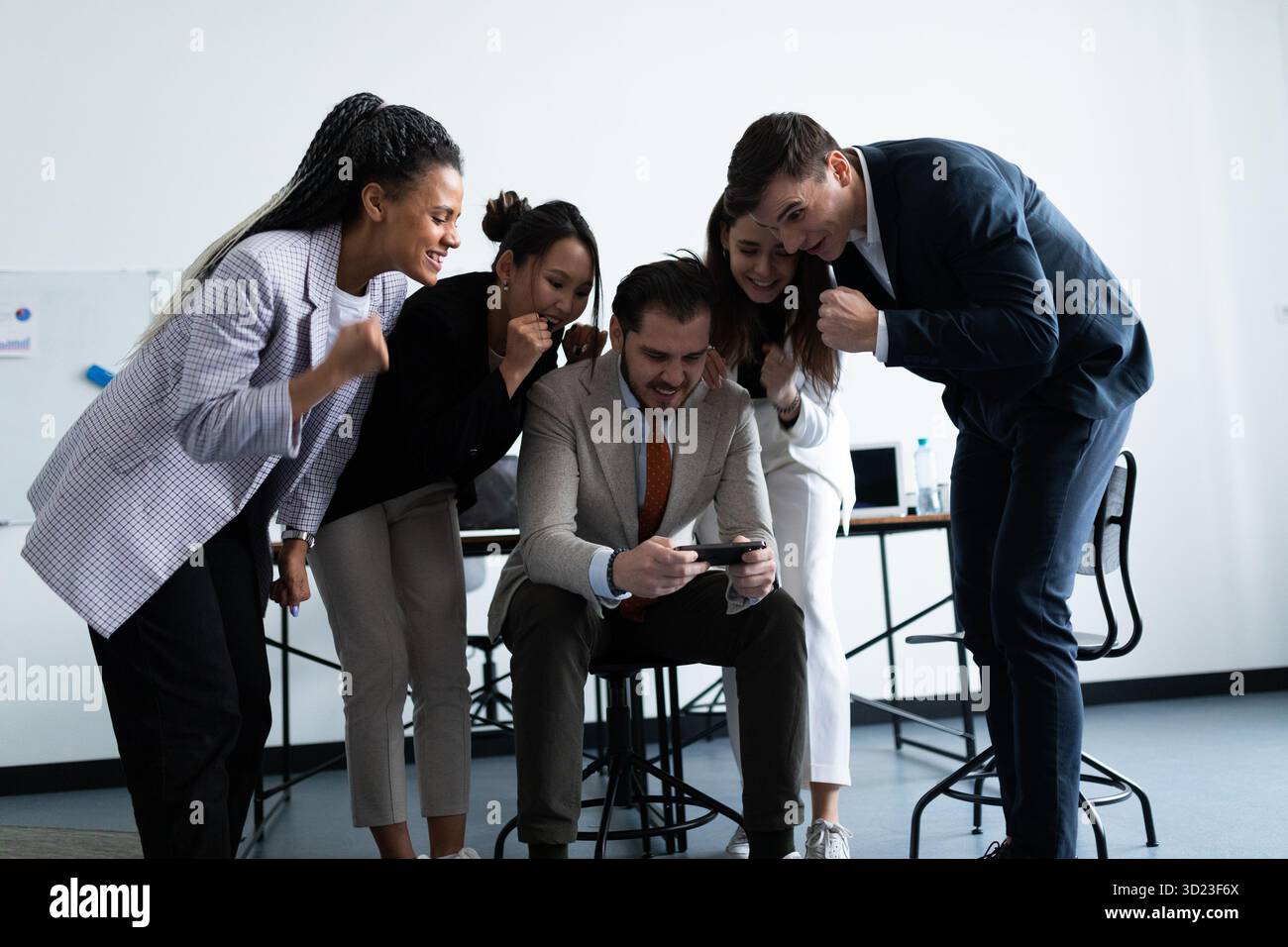 Heureuse équipe d'employés regardant l'écran du smartphone Banque D'Images