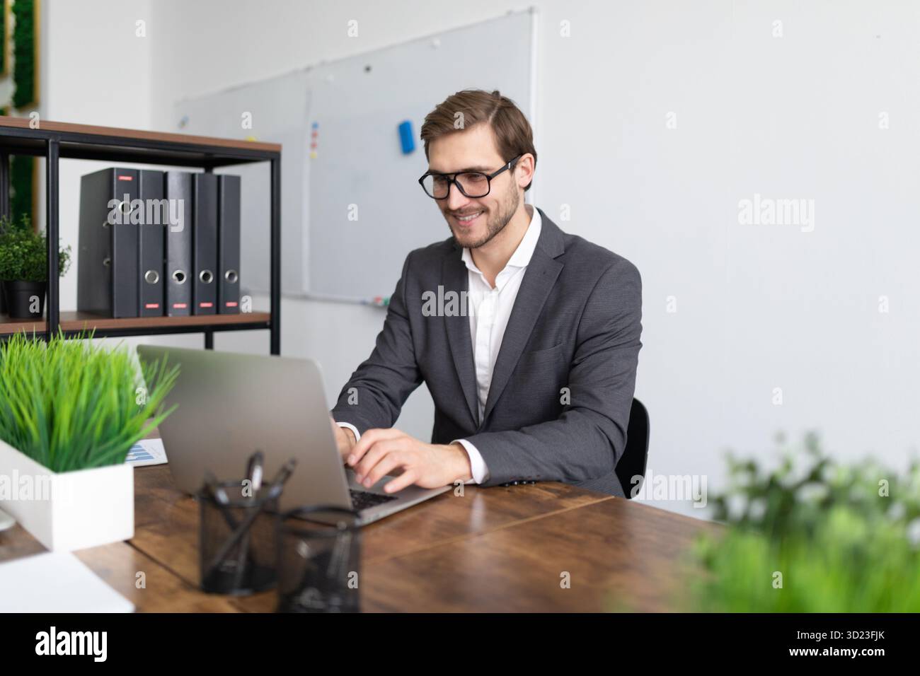 Travailleur financier travaillant sur une tâche professionnelle tout en étant assis avec un ordinateur portable Banque D'Images
