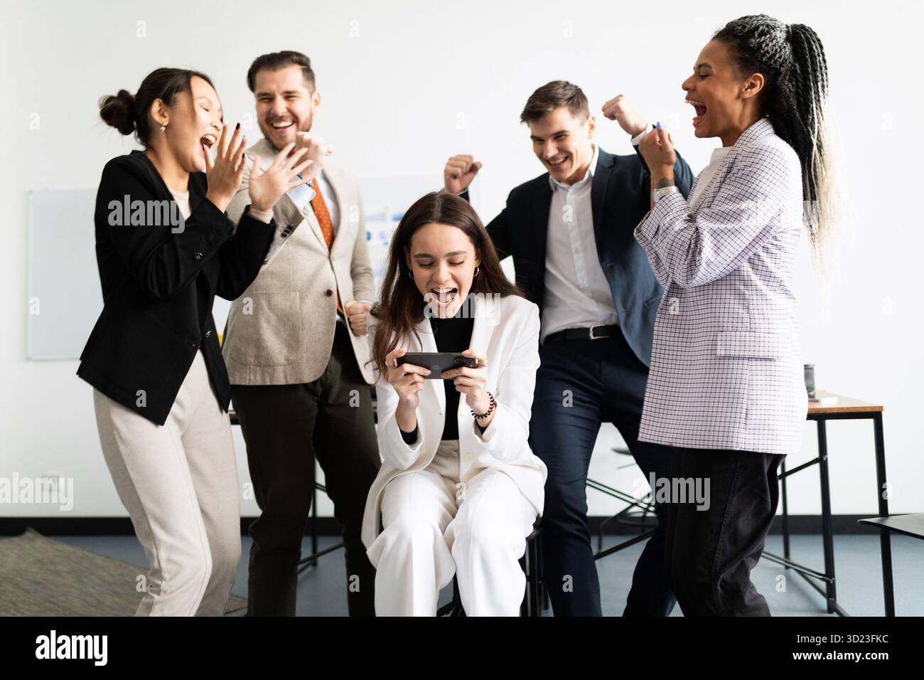Jubilant l'équipe d'affaires regardant l'écran du smartphone Banque D'Images