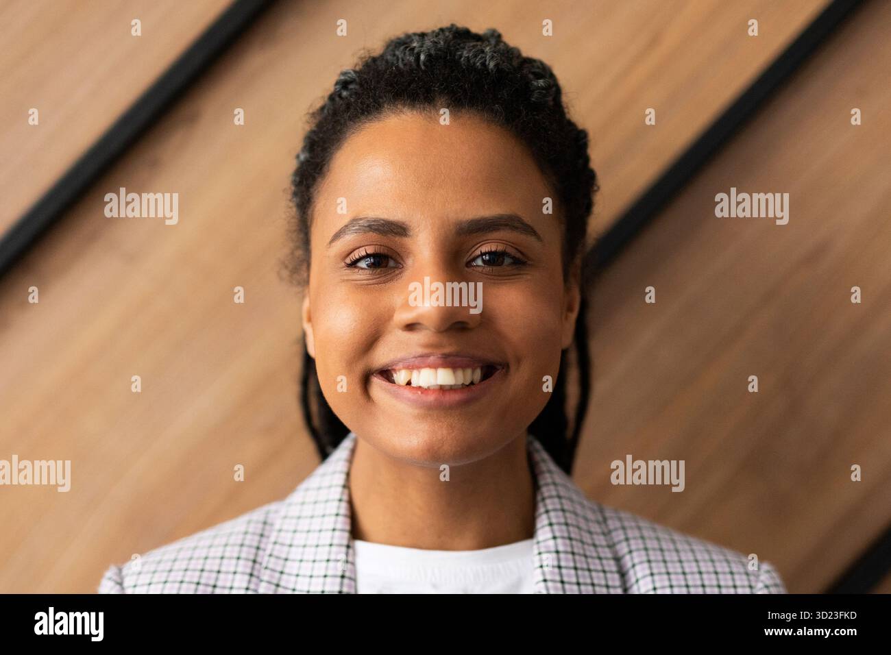 Portrait en gros plan d'une femme afro-américaine contre un mur dans un bureau avec un grand sourire sur son visage Banque D'Images