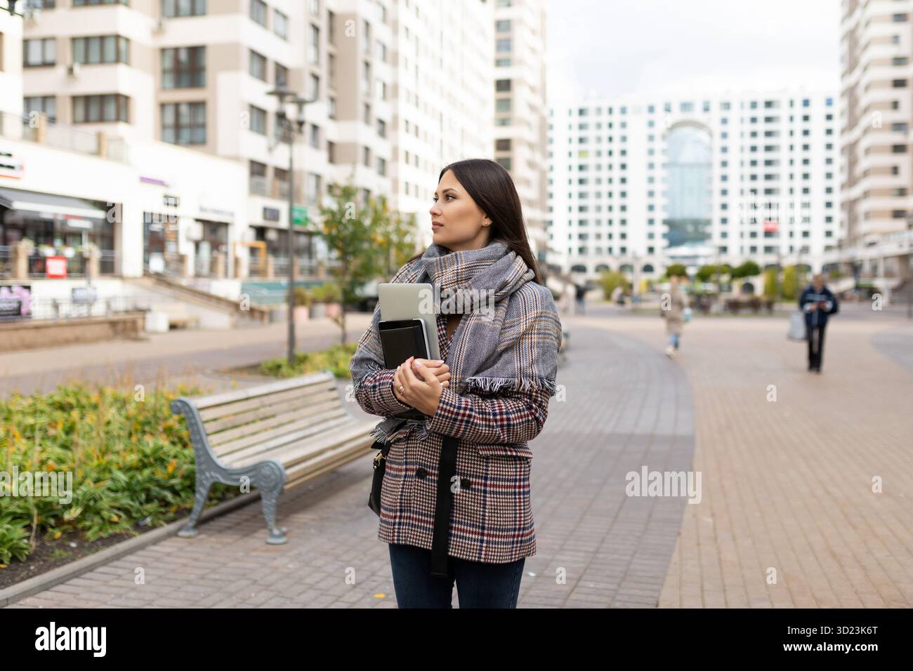 Portrait d'une jeune femme avec un ordinateur portable dans les mains sur fond de bâtiments de la ville Banque D'Images