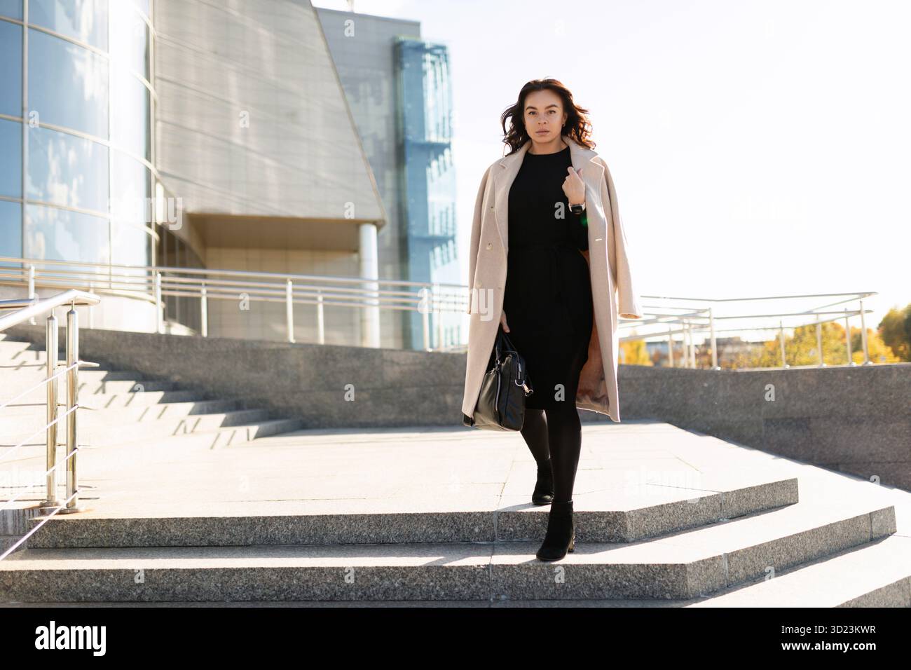 Femme d'affaires dans des vêtements élégants sur le fond d'un immeuble de bureaux Banque D'Images