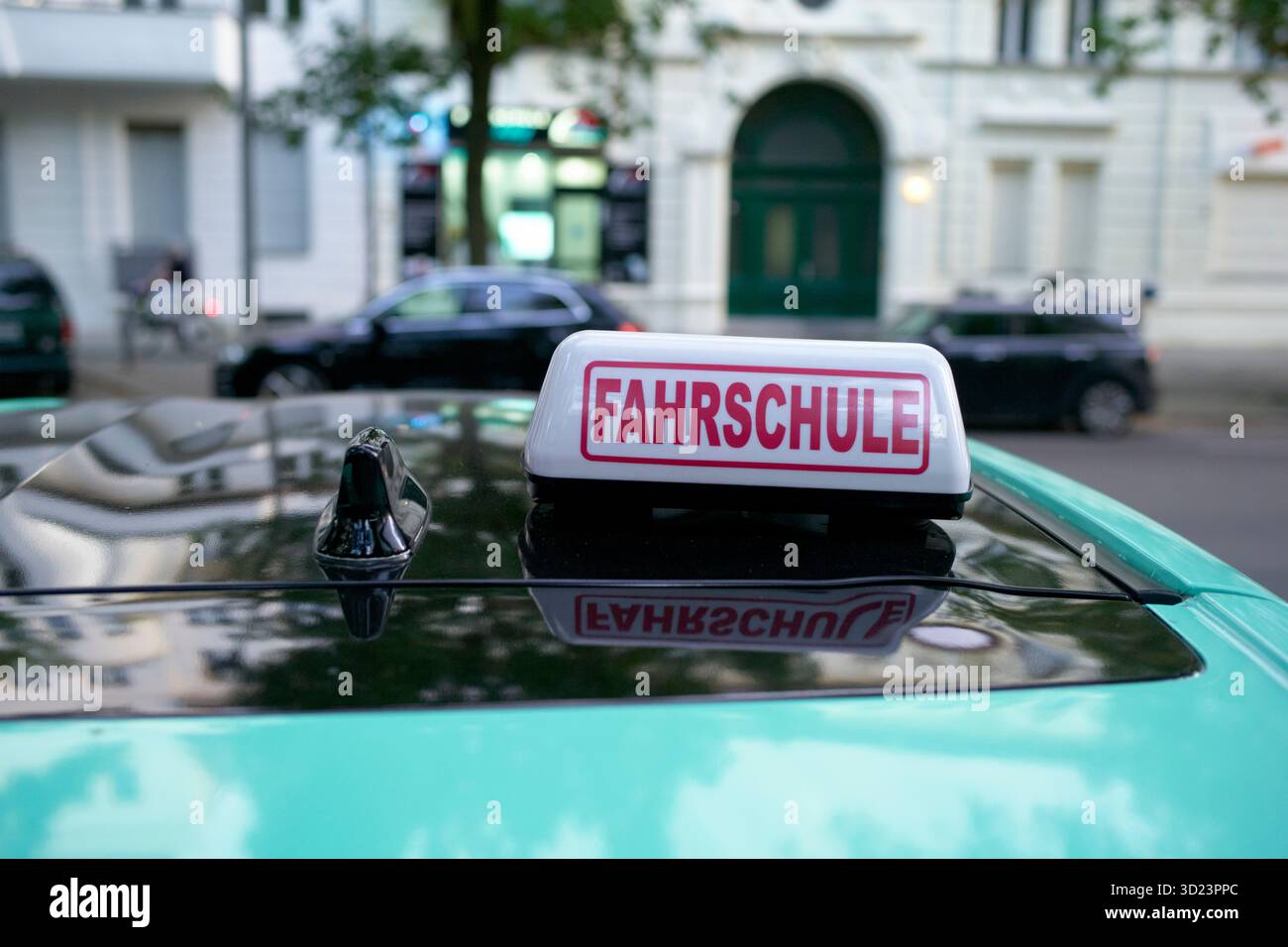 Un panneau d'école de conduite sur le toit d'une voiture avec des bâtiments urbains en arrière-plan. Berlin, Allemagne Banque D'Images