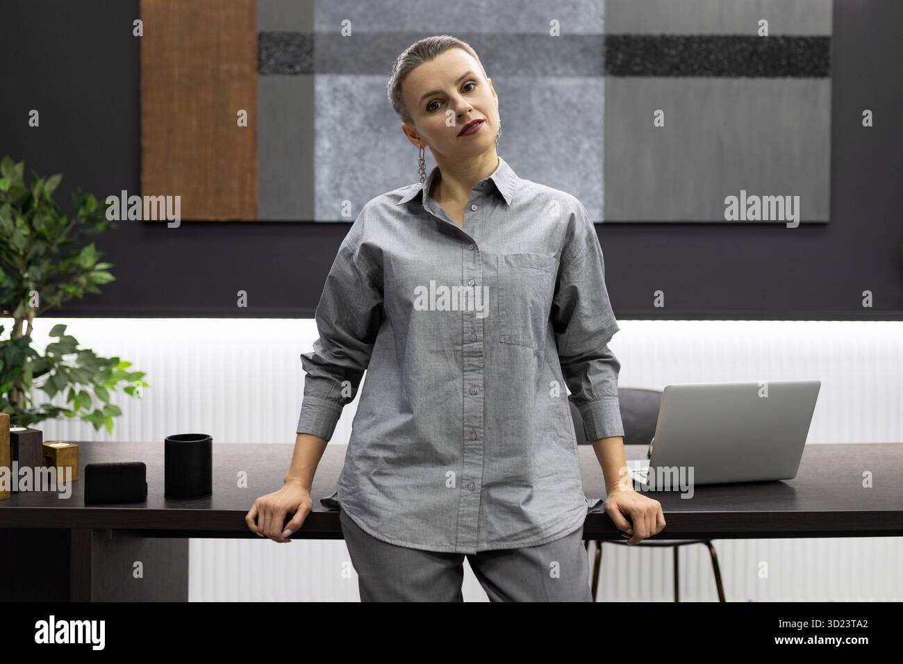 Une femme d'affaires s'est penchée sur une table, sur fond d'un bureau moderne et élégant Banque D'Images