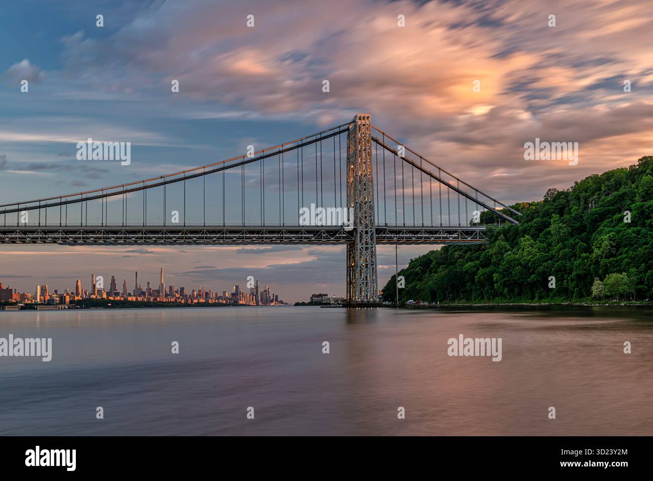 Un pont suspendu majestueux sur une rivière calme avec une ligne d'horizon de la ville sous un ciel coloré. New York City, NY, États-Unis George Washington Bridge, Hudson River Banque D'Images