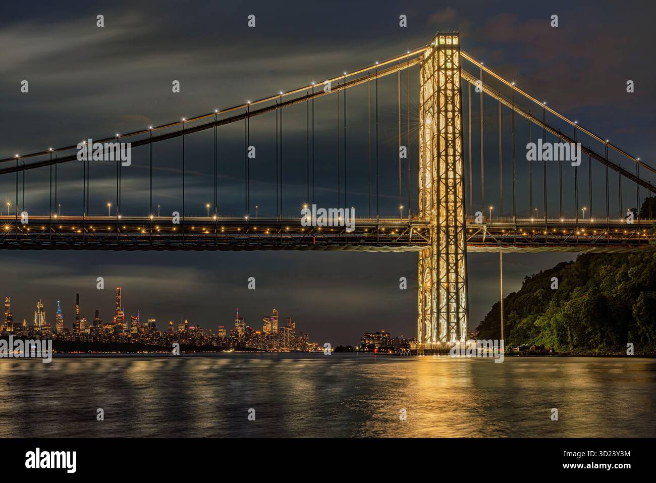Pont suspendu illuminé au-dessus de l'eau calme avec horizon de la ville au crépuscule. New York City, NY, États-Unis George Washington Bridge, Hudson River Banque D'Images