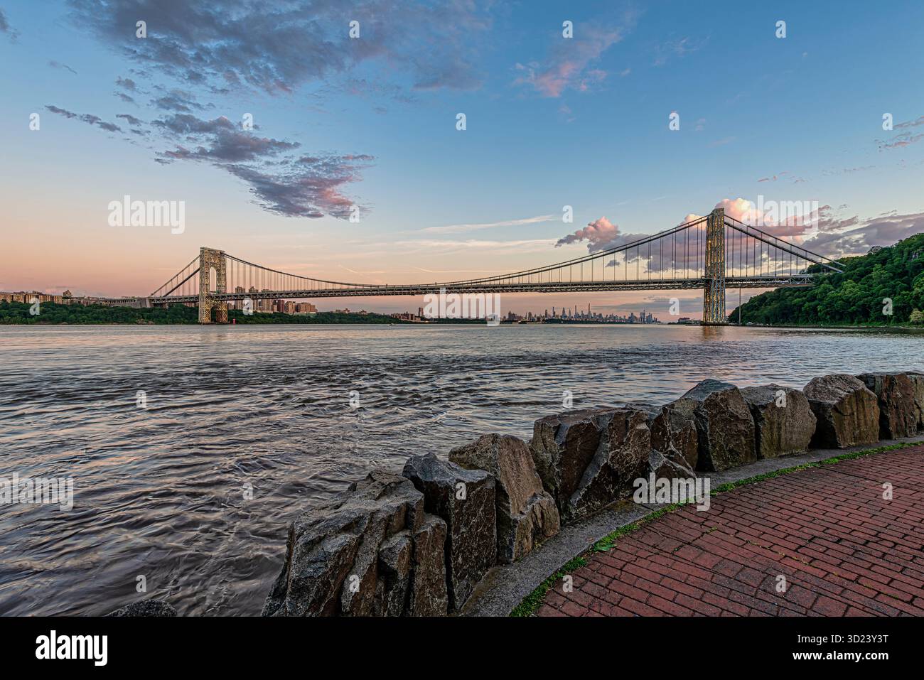 Vue panoramique du pont suspendu sur la rivière avec horizon de la ville et ciel nuageux au coucher du soleil. New York City, NY, États-Unis George Washington Bridge, Hudson River Banque D'Images