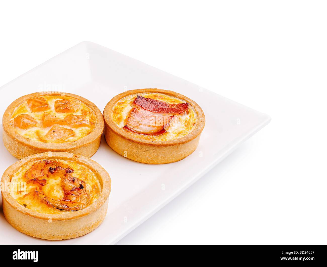 Mini tartes salées avec garnitures assorties présentées sur une assiette blanche Banque D'Images