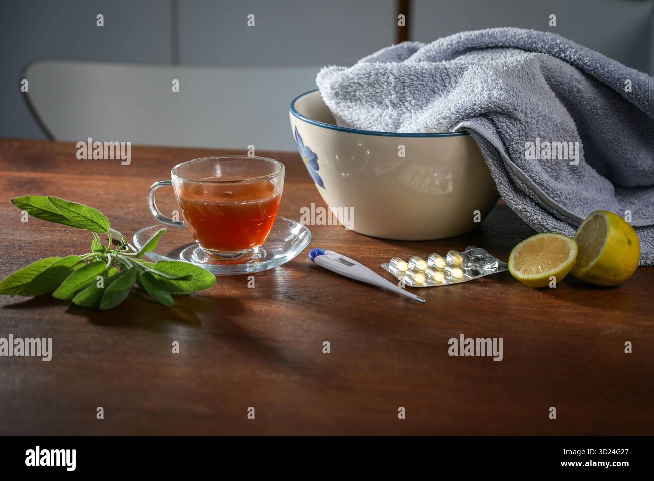 Remède maison contre le rhume et la grippe, tisane, sauge, citron, pilules et un bol avec serviette pour inhalation de vapeur sur une table en bois, concept de santé, selecte Banque D'Images